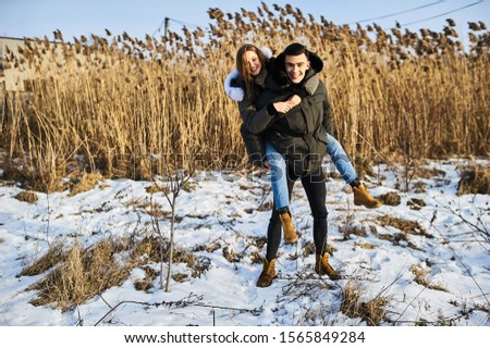 happy couple hugging and laughing outdoors in winter