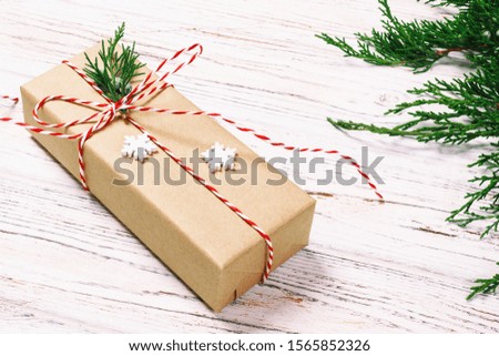 Christmas decorated gift box with fir tree and snowflakes decor on white background top view. Toned.