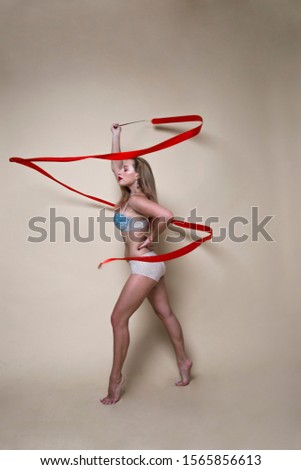 flexible gymnast with red ribbon in the studio