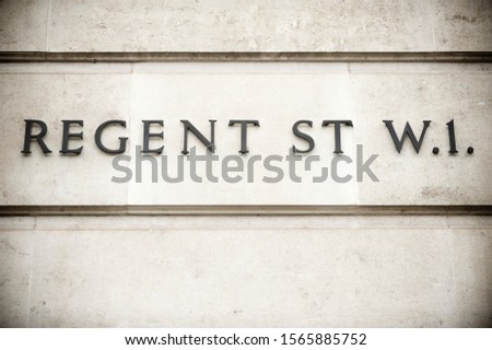 Simple sign for Regent Street in traditional raised metal lettering on old weathered wall in London, UK