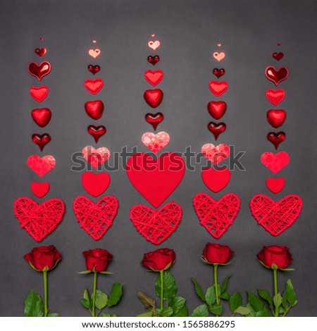 Fresh rose flowers, decorative hearts and sweets in red color on black background. Modern style, creative composition. Love, romance, Valentine's day concept. Flat lay, top view