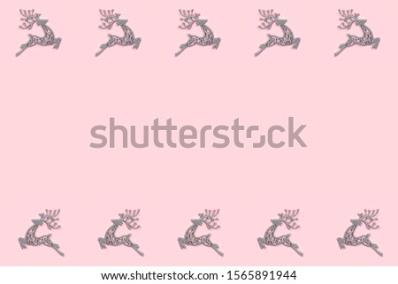 Pattern made of white christmas deer decoration on pastel pink background. Christmas concept. Flat lay, top view.