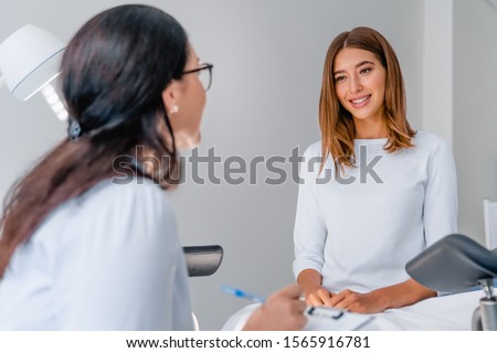 Gynecologist talking with young female patient during medical consultation in modern clinic Royalty-Free Stock Photo #1565916781