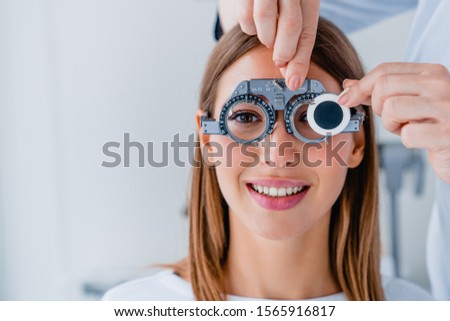 Close up of doctor checking female patient vision with trial frame at eye clinic Royalty-Free Stock Photo #1565916817