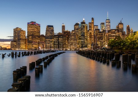 NYC Cityscape in Sunset Light. Old Pier in Foreground. Lower Manhattan Cityscape in Background. Skyscraper