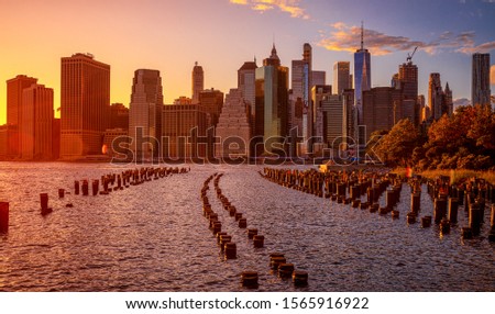 NYC Cityscape in Sunset Light. Old Pier in Foreground. Lower Manhattan Cityscape in Background. Skyscraper