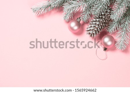 Christmas pink flat lay background with fir tree and decorations on pink layout. Top view with copy space.