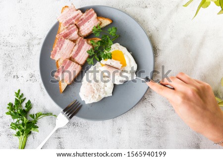 Poached eggs with bacon on sourdough toast. isolated on white marble background. Homemade food. Tasty breakfast. Selective focus. Hotizontal photo.