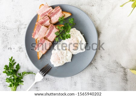 Poached eggs with bacon on sourdough toast. isolated on white marble background. Homemade food. Tasty breakfast. Selective focus. Hotizontal photo.