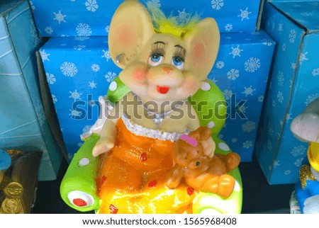 Funny toy mouse souvenir in the image of a fashionable woman on a store shelf. Sale of New Year gifts in a supermarket. Advertising and marketing of goods for the holiday concept.

