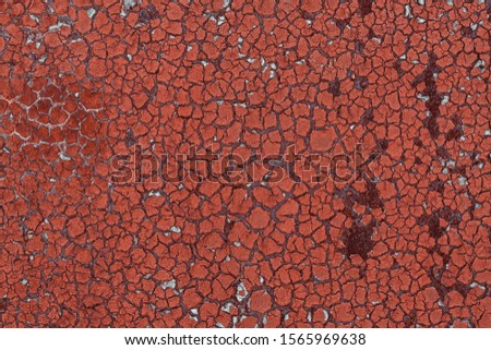 Old rusted metal wall with cracked and partly peeled red paint. Grunge background and texture