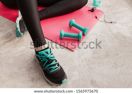Stock photography of a young woman exercising at home in the living room