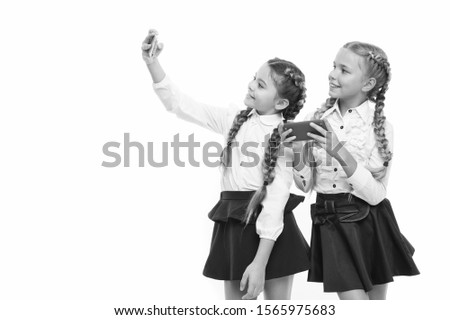 The best phones for taking selfies. Small children using phone cameras for shooting isolated on white. Little girls having e-lesson on mobile phones. Cell phones as educational tools, copy space.