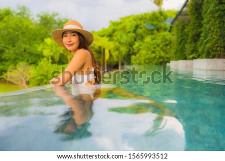 Portrait beautiful young asian women happy smile relax around outdoor swimming pool in hotel resort