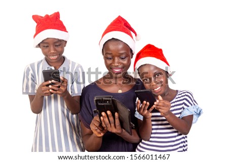 beautiful family wearing a christmas hat looking at  screen of his mobile phone while smiling.