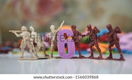 Image of number 6 with six toy soldiers at background