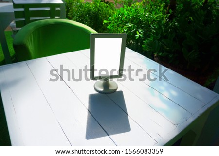 Display stand for acrylic tent card in coffee shop - Mockup menu frame on table in bar restaurant with morning light