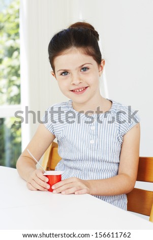 Young girl eating yogurt