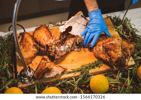 Chef carving roasted turkey for Thanksgiving or Christmas holidays