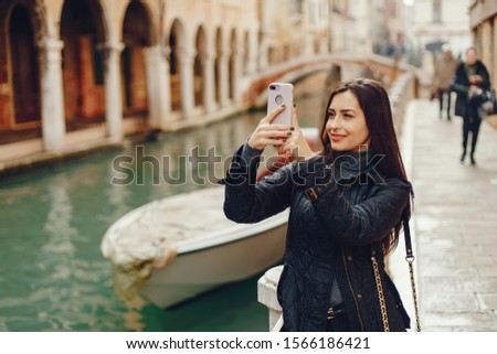girl talking on the phone and taking pictures in Venice Italy