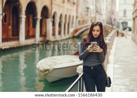girl talking on the phone and taking pictures in Venice Italy