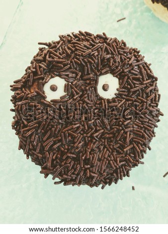 Closeup Image of Chocolate Doughnut or Donut with an Icing of Anxious Facial Expression made from Sprinkles