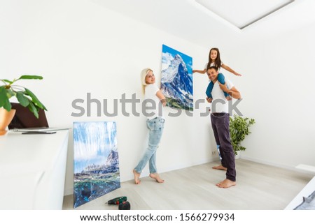 family hangs a large photo canvas at home