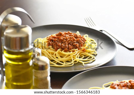 Spaghetti Bolognese with minced beef, onion, chopped tomato, garlic, olive oil, stock cube, tomato puree and Italian herb. Traditional Italian food in black plate. Selective focus.  