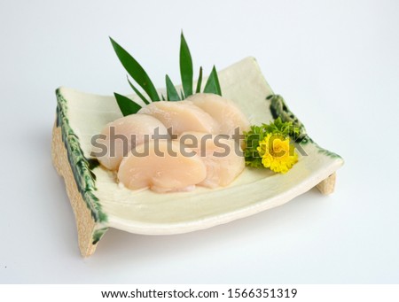 Sliced raw Hotate shell sashimi on ceramic plate Royalty-Free Stock Photo #1566351319