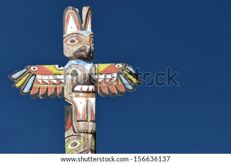 Isolated totem wood pole in the blue background