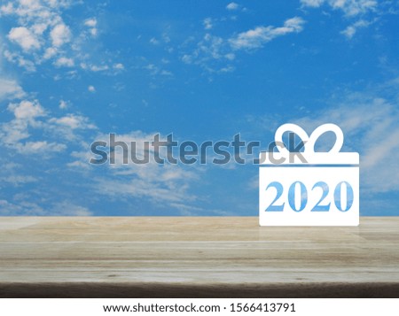Gift box happy new year 2020 flat icon on wooden table over blue sky with white clouds, Business shop online concept