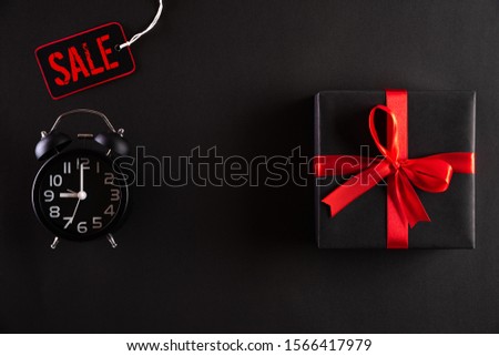 Top view of Black Friday Sale text with black gift box with Alarm clock on white background. Shopping concept boxing day and black Friday composition.