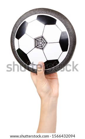 Hand with soccer hover ball, flying toy for kids. Isolated on white background.
