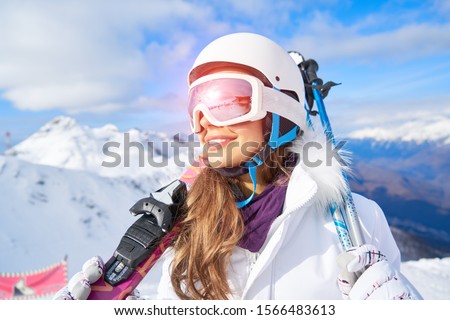              Portrait of beautiful woman with ski and ski suit in winter mountain.                   