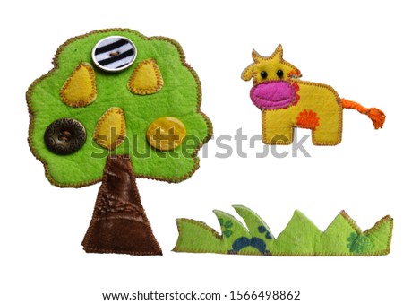 Felt application cow, tree and grass on a white background. Mockup for design. Fine motor development.