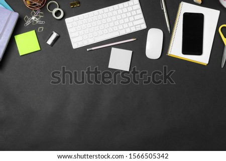 Flat lay composition with keyboard, smartphone and stationery on black background, space for text. Designer's workplace
