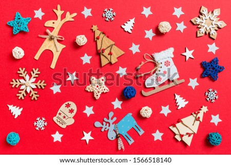 Top view of holiday toys and decorations on red Christmas background. New Year time concept.