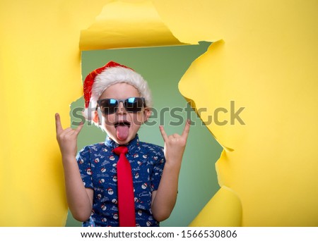Happy funny child boy face portrait. Kid in glasses and Santa Clause shirt. Christmas party night. Happy xmas and New Year.