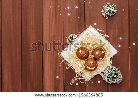 Homemade chocolate candies with star sprinkles. Festive sweet dessert, Christmas (New Year) spirit. Wooden boards background, copy space, top view