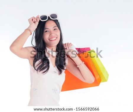 Asian women carrying shopping bags and raising credit cards with smiling faces on a white background. The concept of living a happy life