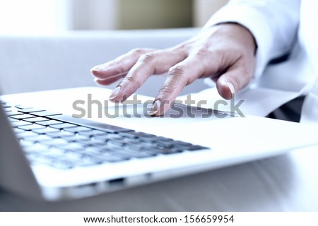 Female hands typing on a laptop track pad