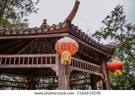 China travel chinese red lanterns hanging on a wooden pagoda or gazebo in nature park for Chinese New Year Lunar Celebration banner background