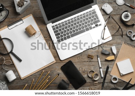 Flat lay composition with laptop, smartphone and stationery on wooden table. Designer's workplace