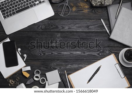 Flat lay composition with laptop. smartphone and stationery on black wooden table, space for text. Designer's workplace