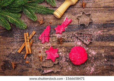 Cooking red ginger cookies. Traditional Christmas pastries. Festive culinary background. Fir tree, spices, cutters, raw dough, rolling pin, wooden boards, top view, close up