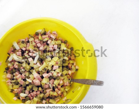 Diced ingredients in a yellow bowl on a white table