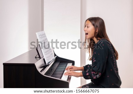 Girl playing the piano, she is very happy,