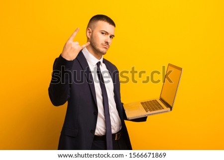 young handsome businessman  against flat background holding a laptop