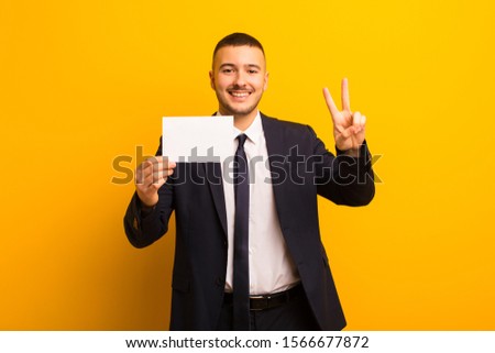 young handsome businessman  against flat background with a placard