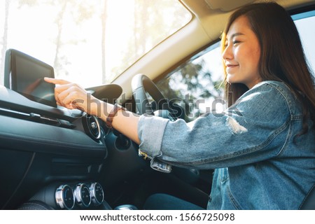 Closeup image a beautiful woman using and pointing finger at navigation screen while driving car
